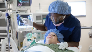 A CRNA is pictured with a pediatric patient about to receive anesthesia.