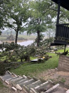 The aftermath of the flood shows broken tree limbs in a yard.