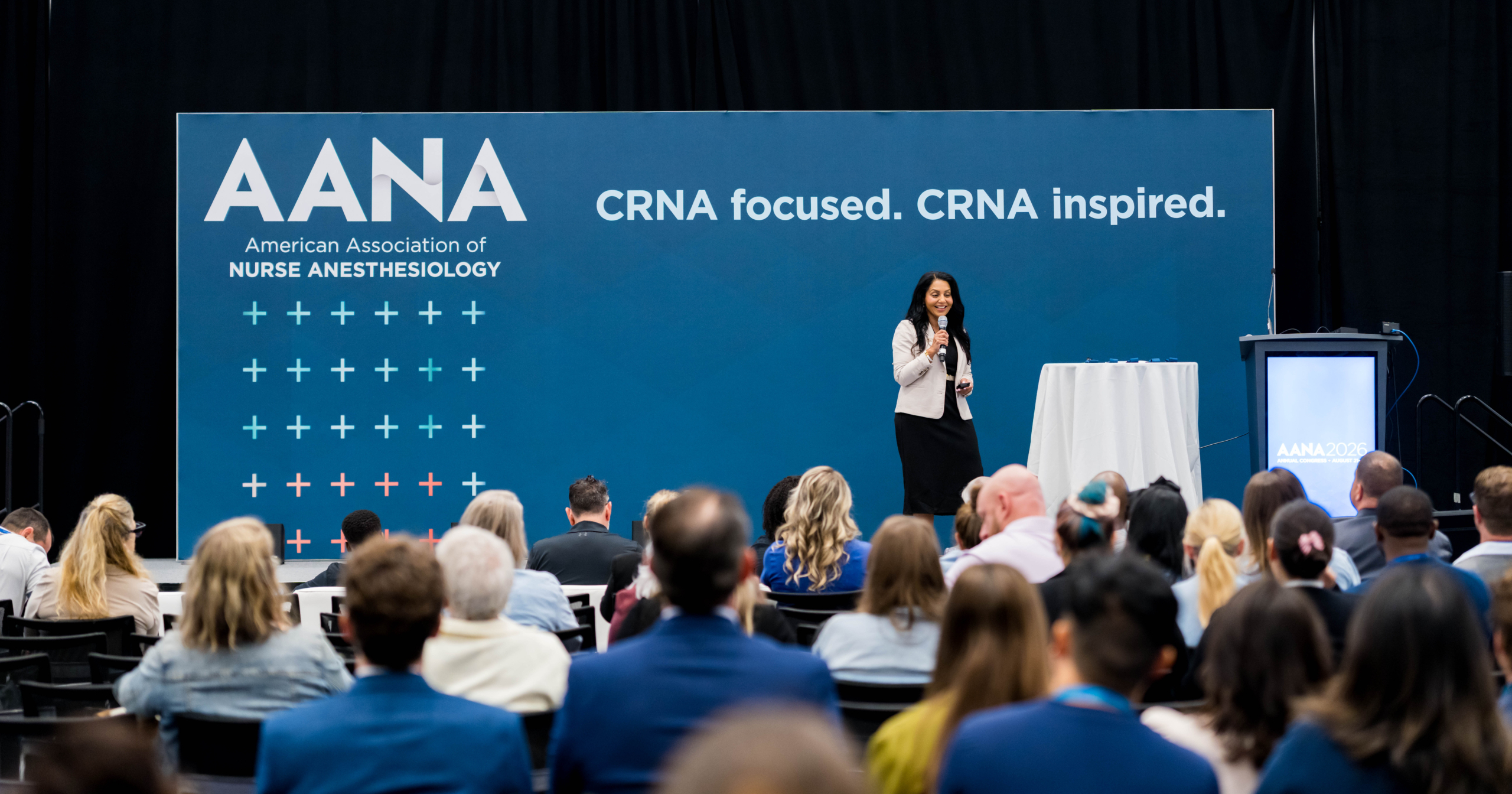Presenter addresses a seated audience at the 2026 AANA Annual Congress beneath “CRNA focused. CRNA inspired.” signage.